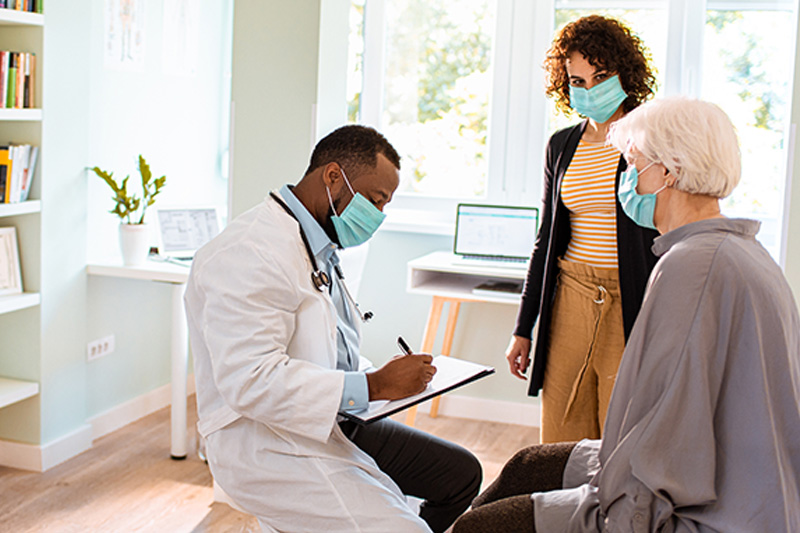 doctor talking with senior lady and daughter