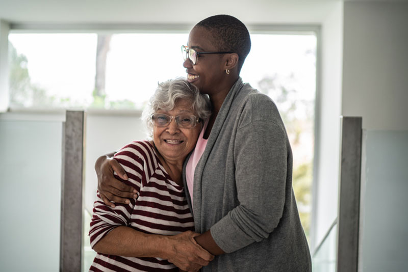 A woman embraces her aging mother and uses other tips to help relieve anxiety in seniors to improve her mother’s quality of life.
